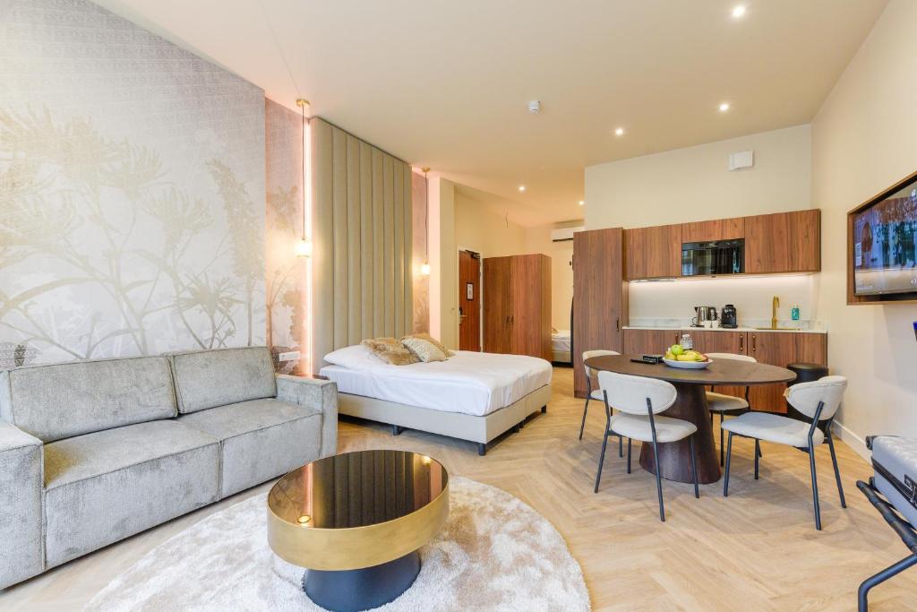 uma sala de estar com um sofá e uma cama em Novallure Villa Margaretha - Short Stay Apartments em Rijswijk