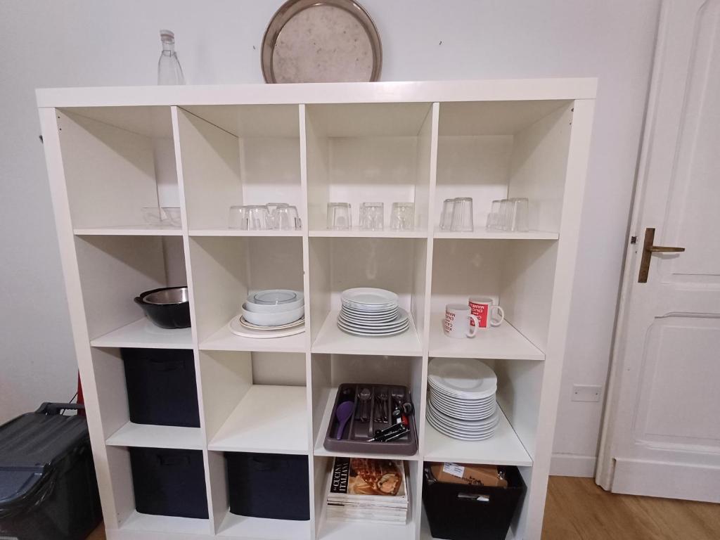 a white pantry with plates and dishes on shelves at PERUSIA HOME in Perugia