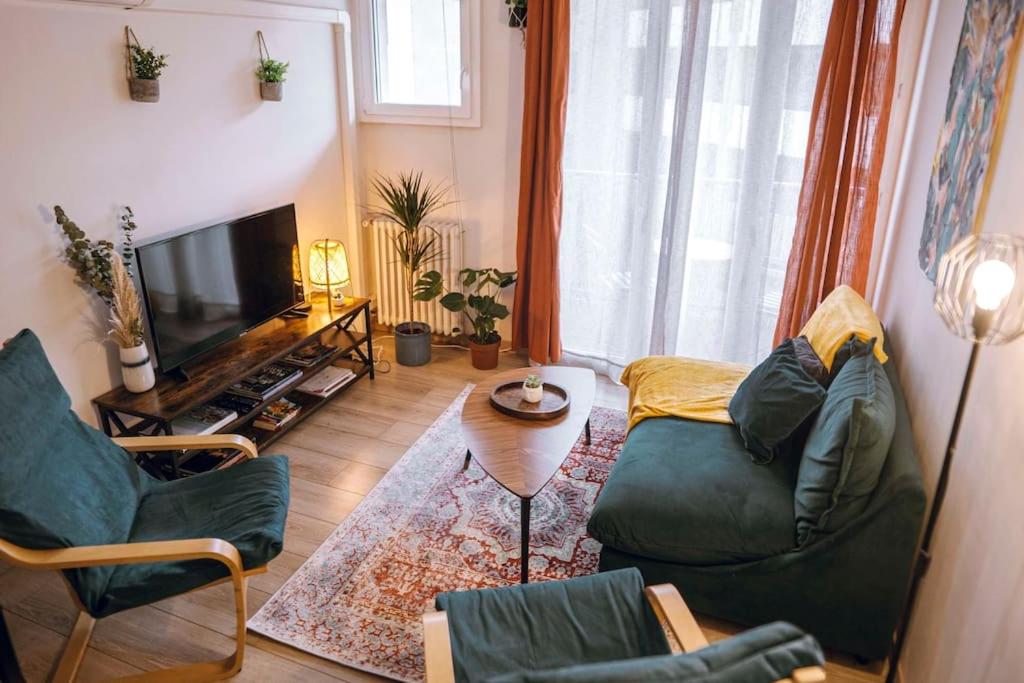 un salon avec deux chaises et une télévision dans l'établissement Cozy 2 bedroom Artbnb Toulouse train station Garage Wi-Fi, à Toulouse