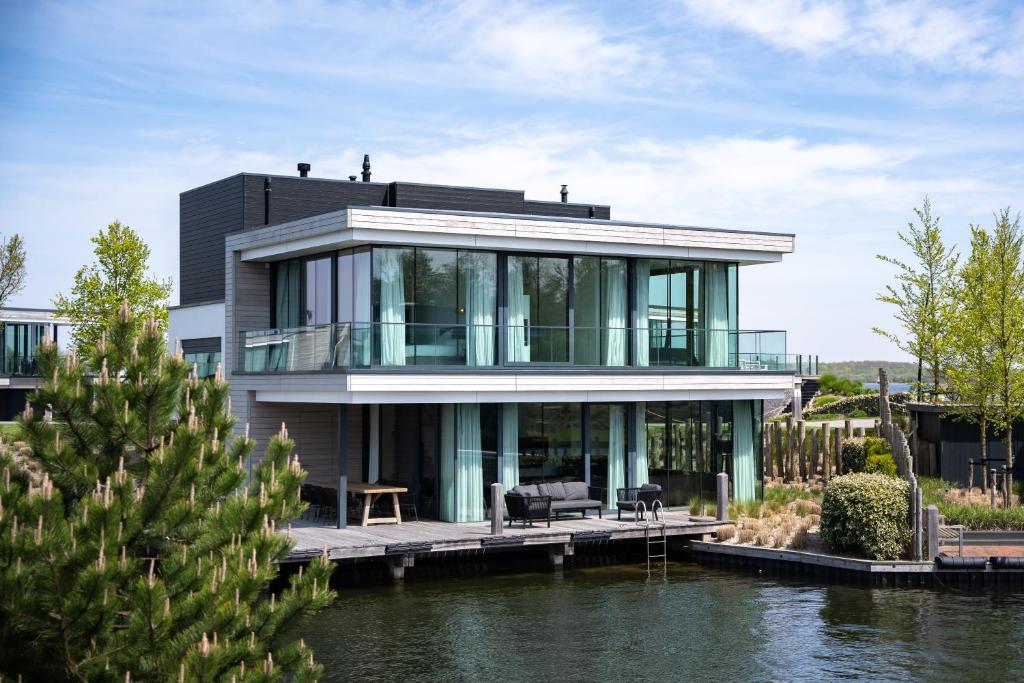 a house on the water with a dock at Dormio Harbour Village in Arnemuiden