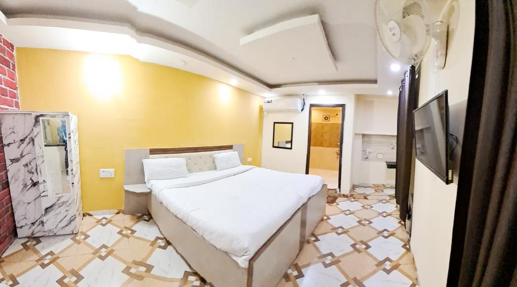 a bedroom with a bed and a yellow wall at Roomshala 160 Hotel Red - Vasant Kunj in New Delhi
