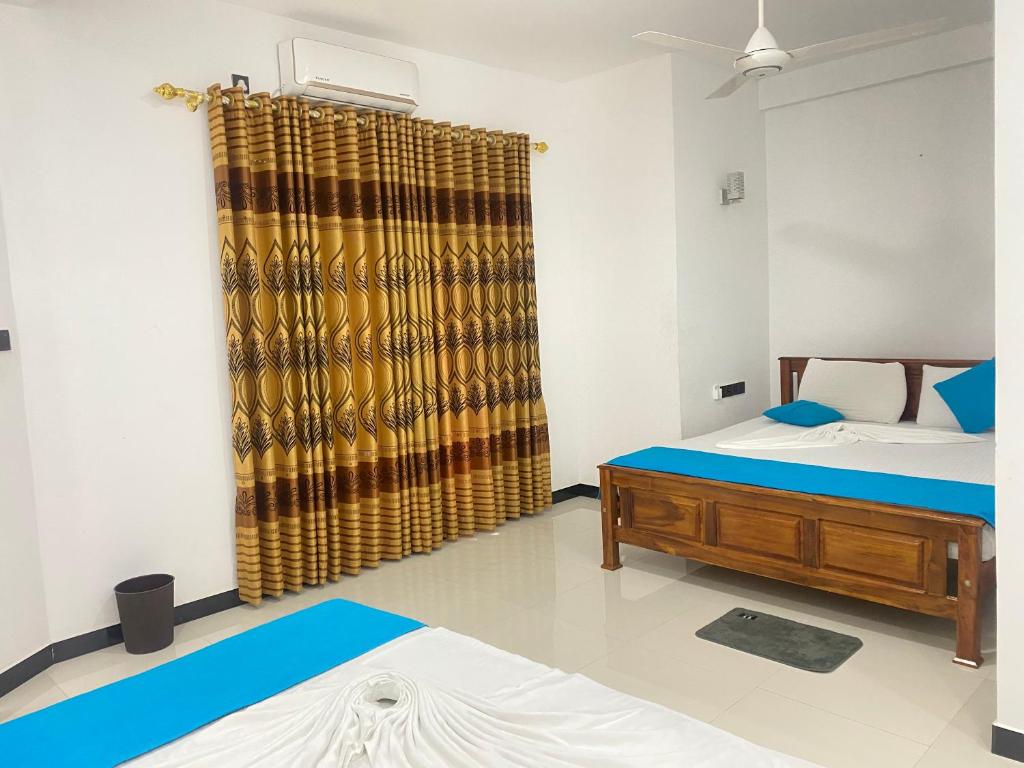 ティッサマハーラーマにあるLa Maison Yalaのベッド2台とシャワーカーテンが備わる客室です。