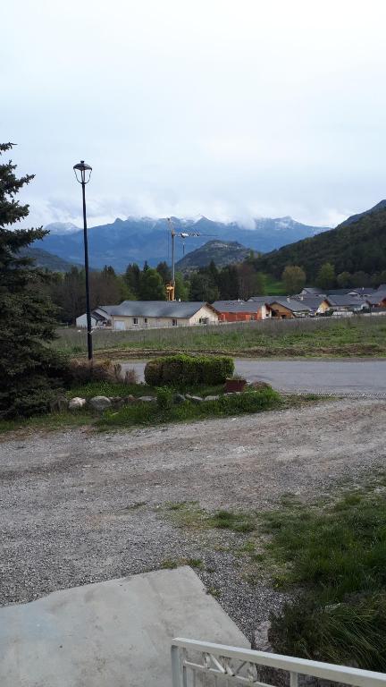 un parking vide avec des montagnes en arrière-plan dans l'établissement Appartement dans maison, à Saint-Étienne-le-Laus