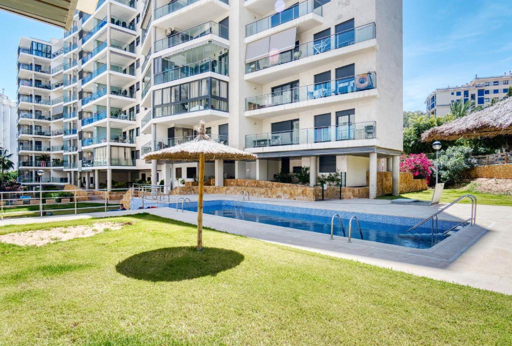 a large apartment building with a swimming pool and an umbrella at Marinada in Benidorm