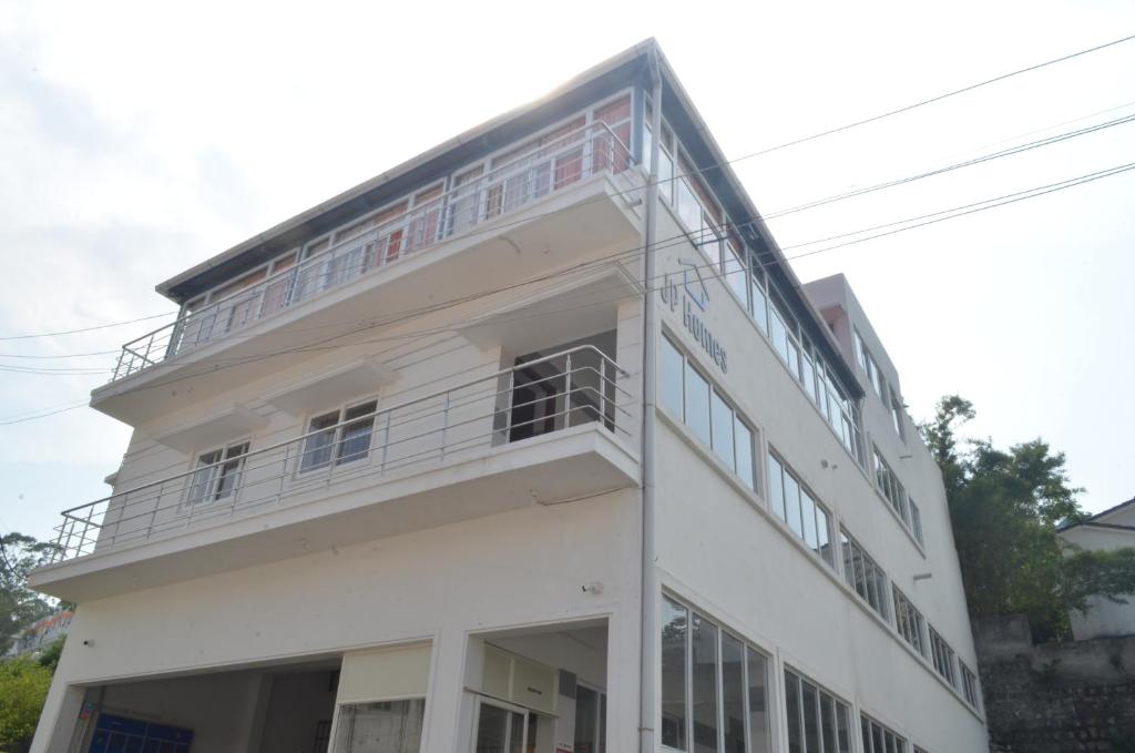 un edificio blanco con balcón en la parte superior en JP Homes, en Yercaud
