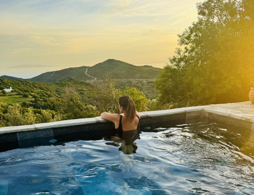 a woman in a hot tub with a view at Villa Kotseli - Sea View, Pool, Sunsets in Andros