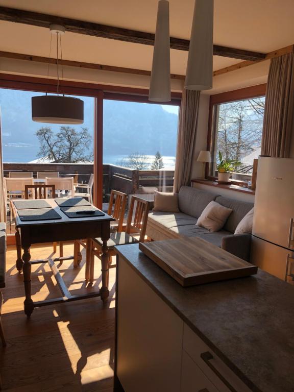 uma cozinha e sala de estar com um sofá e uma mesa em Pension Christina em Unterach am Attersee