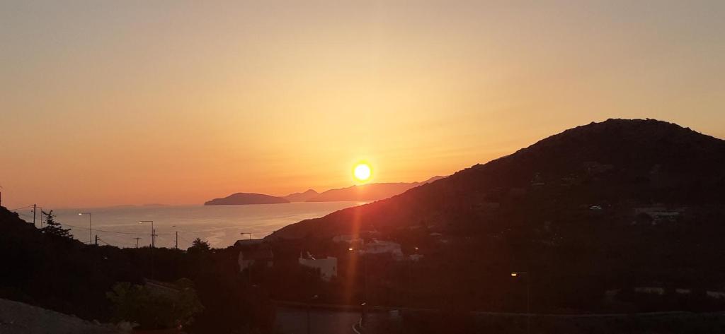 a sunset with the sun setting over the ocean at Hari Apartments Vathi, Agios Nikolaos Crete in Vathi