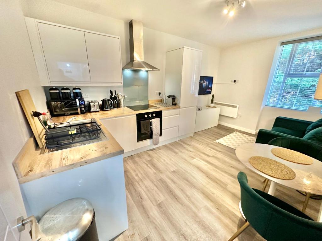 a kitchen and a living room with a table at Spacious One Bedroom Apartment - With Parking and WiFi - Town Centre Location - Gated Access - Walk to Beach! in Bournemouth