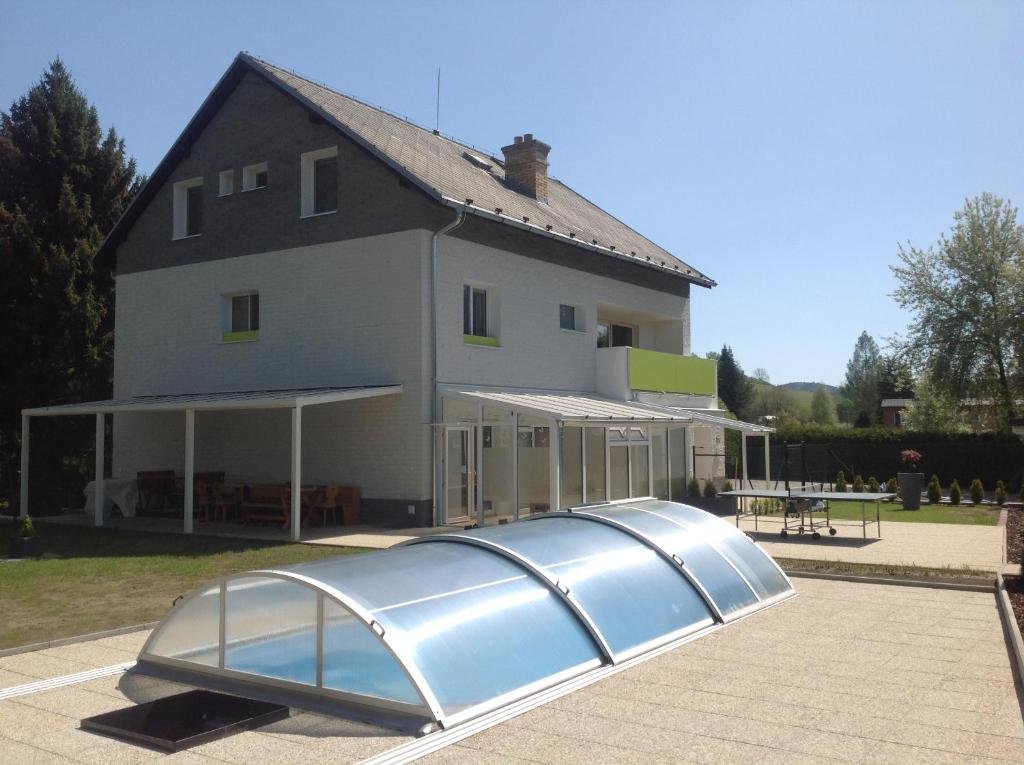 uma casa com um objecto metálico à sua frente em Penzion Zelená zahrada em Kladenské Rovné