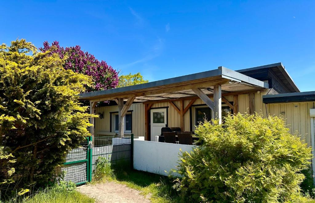 a house with a porch with a fence and trees at Haus auf der alten Düne 2 in Prerow