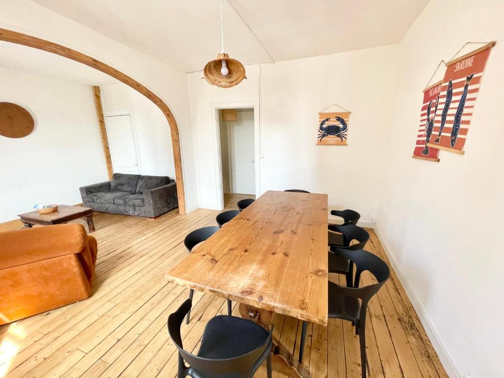 une salle de conférence avec une table et des chaises en bois dans l'établissement Joli T4 au coeur de Berck-Plage, à Berck-sur-Mer