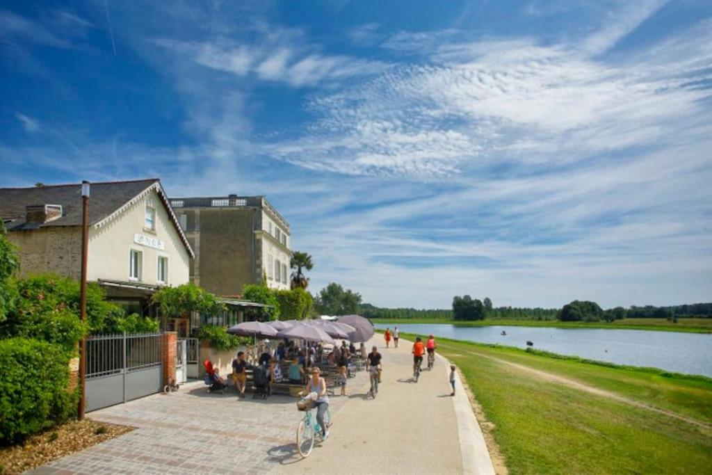 un groupe de personnes marchant sur un trottoir près d'un lac dans l'établissement Grande maison familiale au calme, à Bouchemaine