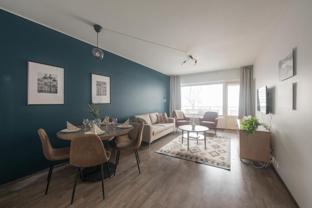 a living room with a table and a couch at Forenom Serviced Apartments Helsinki Lastenkodinkuja in Helsinki