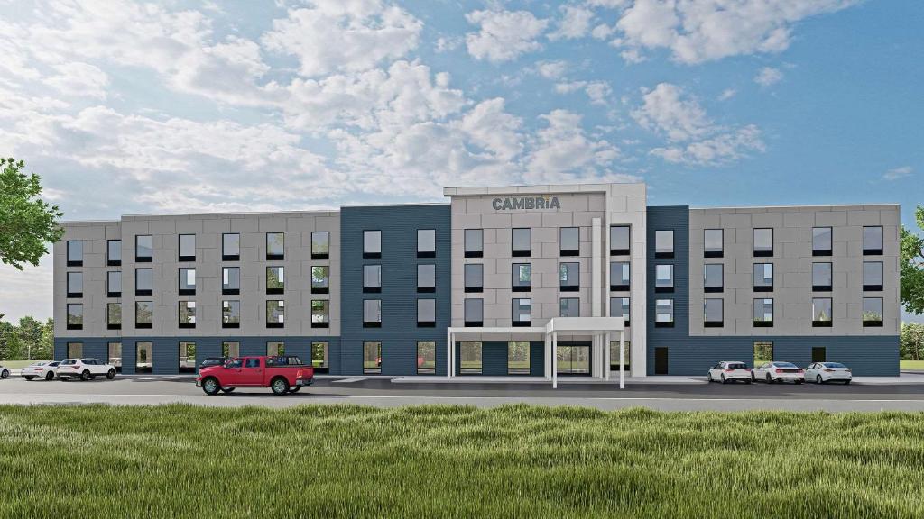 Cambria Hotel Plymouth في بليموث: تقديم مبنى مستشفى بالسيارات الواقفه امامه