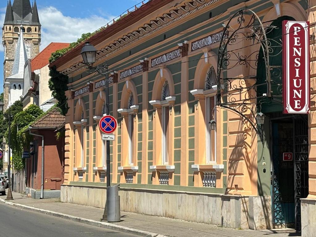 a building on a street with a sign in front of it at Pensiunea Casa Rusu in Baia Mare