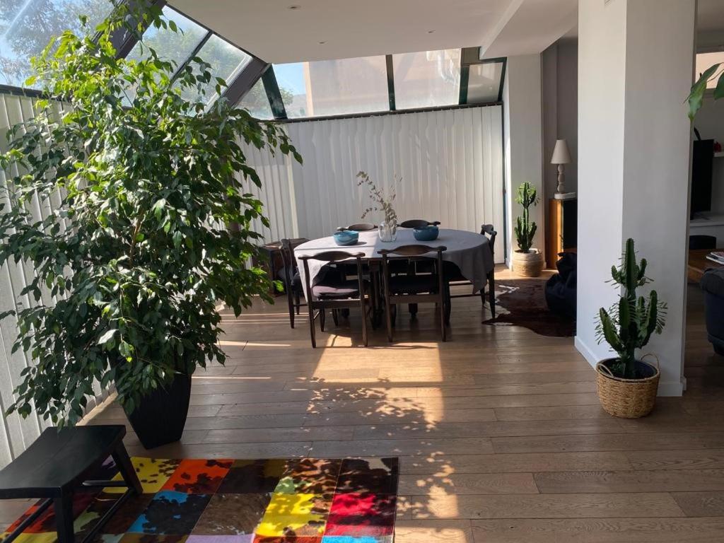 une salle à manger avec une table et des plantes dans l'établissement Bel hébergement spacieux et calme - idéal pour visiter Paris et Versailles, à Antony