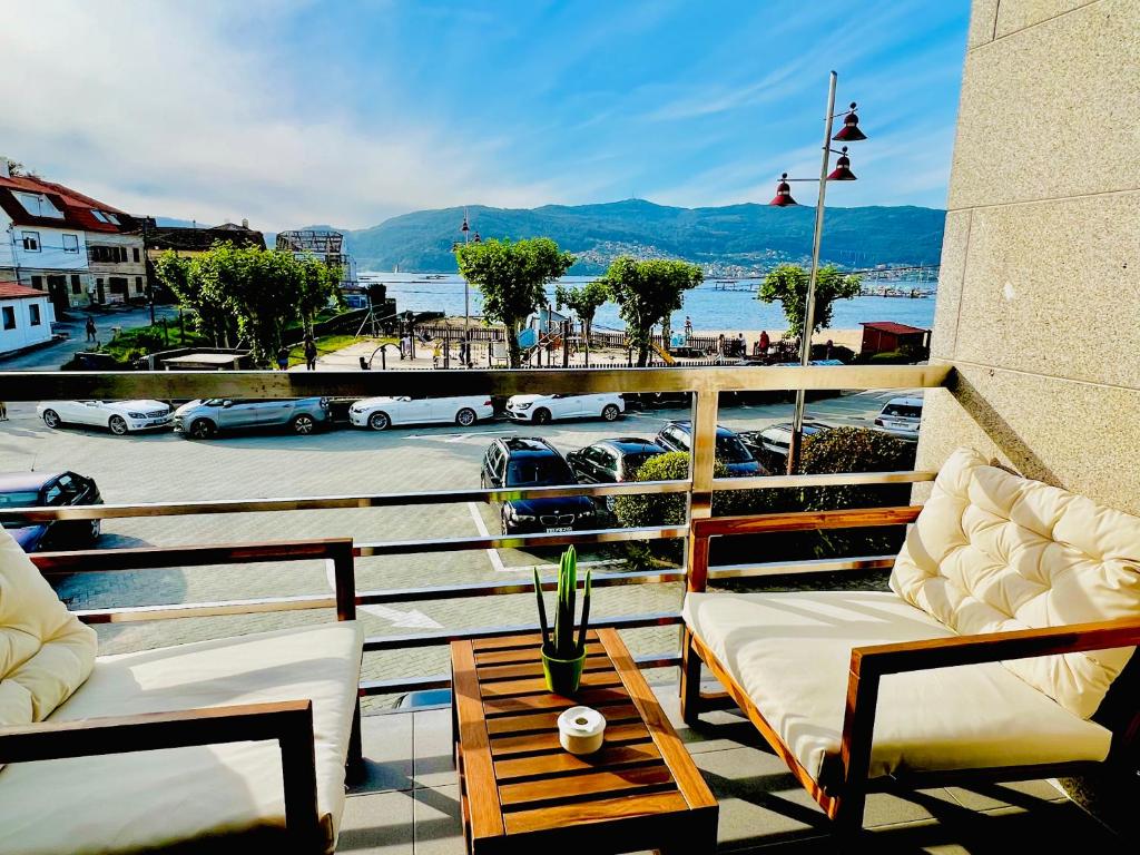 balcón con sillas y mesa y vistas al puerto en Apartamento Exclusivo a pie de Playa en Vigo