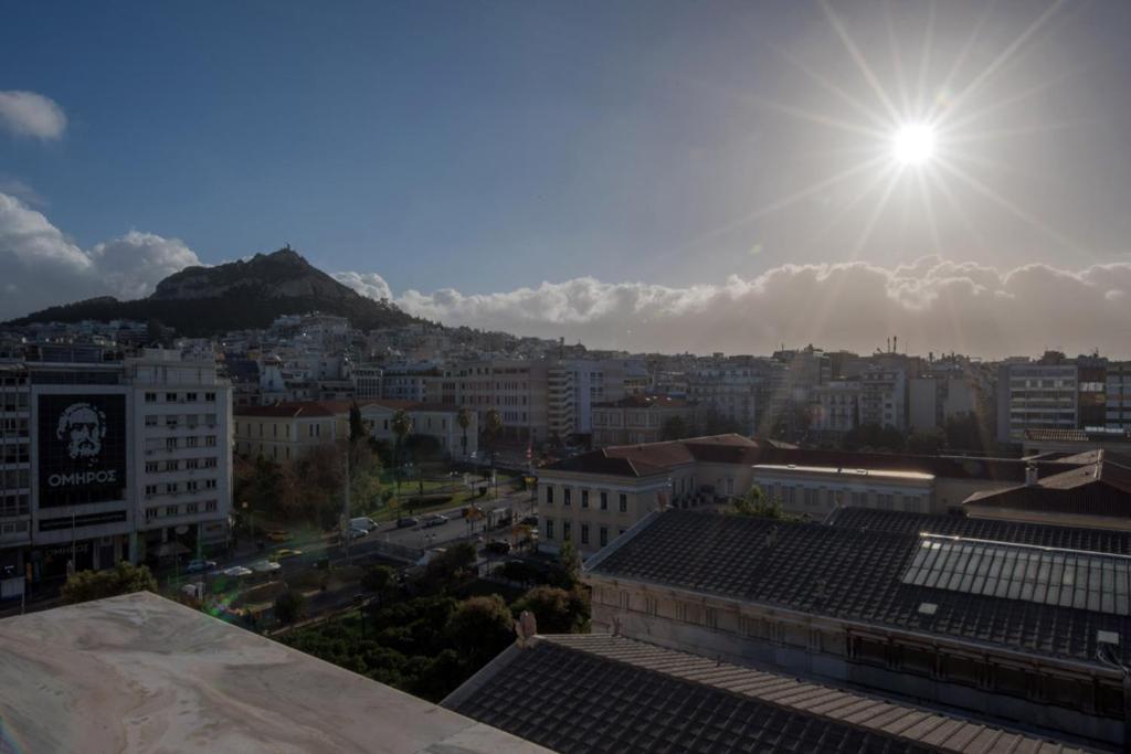 uma vista para uma cidade com o sol no céu em Holodek Apartments Ippokratous em Atenas