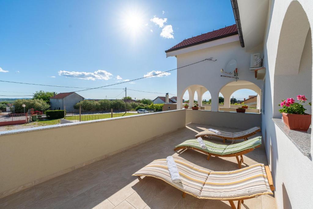 a balcony with chairs and a view of the ocean at Ema's Olive Garden Apt 2 -private parking, 10 min drive from sandy beach in Poličnik