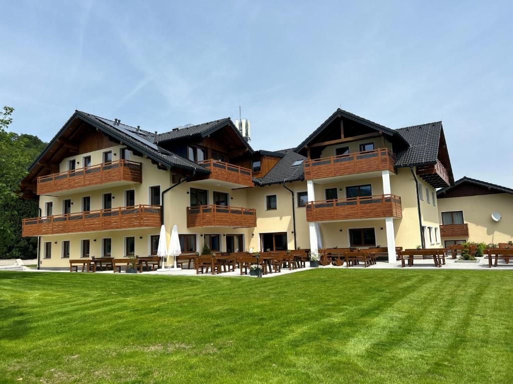 a large building with a lawn in front of it at Gasthof Steinbichler in Nussdorf am Attersee