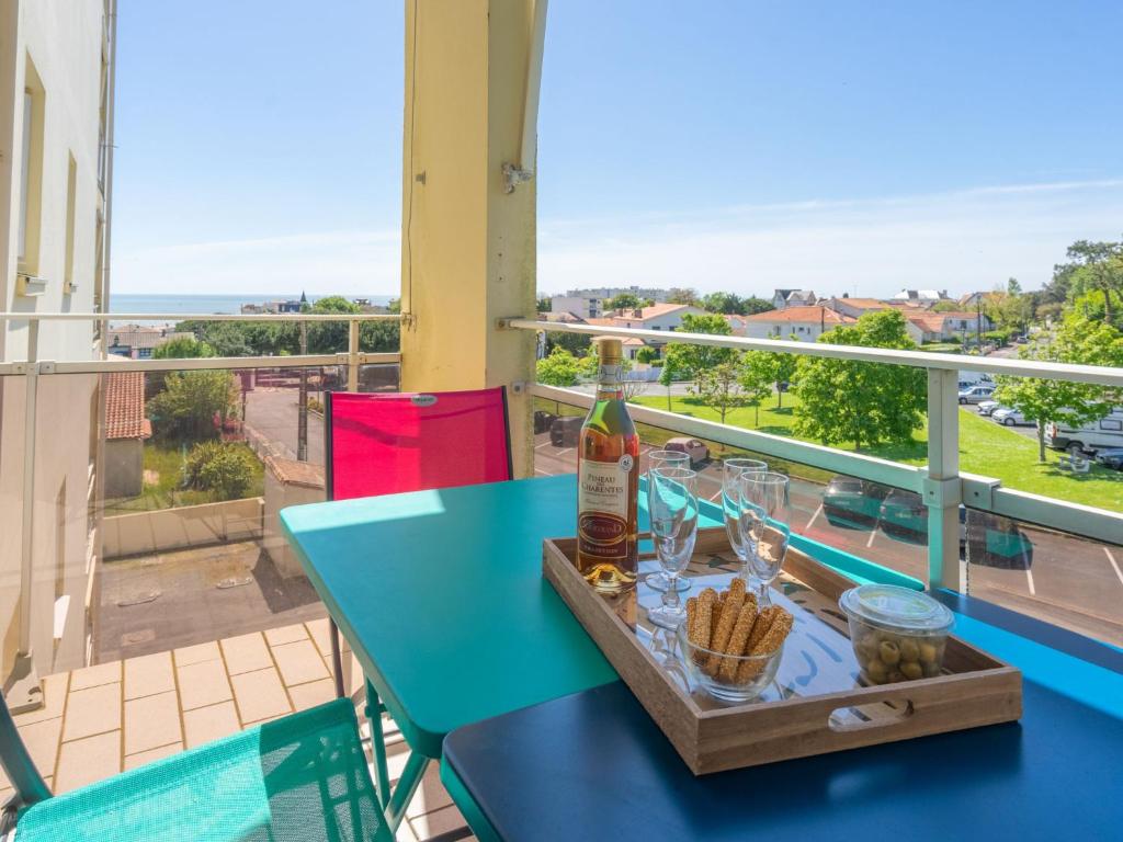 - une table avec une bouteille de vin et des collations sur le balcon dans l'établissement Apartment Le Yachting-2 by Interhome, à Royan