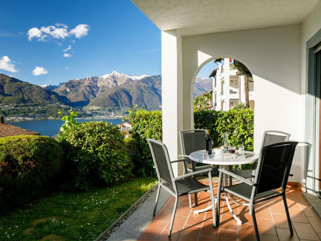Apartment Miralago - Utoring-43 by Interhome في Piazzogna: طاولة وكراسي على شرفة مطلة على الجبال