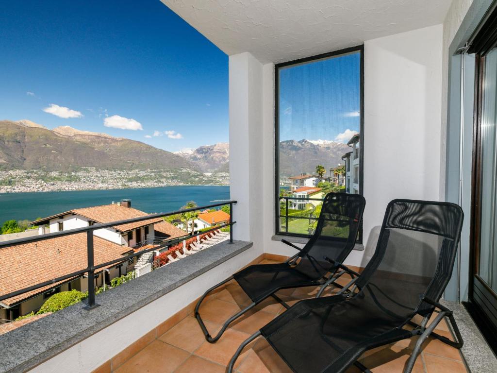 two chairs on a balcony with a view of the water at Apartment Residence Miralago - Utoring Apt- B16 by Interhome in Piazzogna