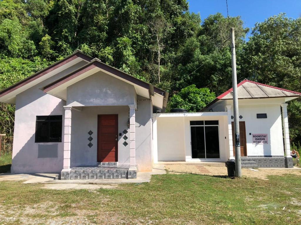 瓜拉丁加奴的住宿－Rest House Idaman BB Rumah tak kongsi，一间白色的小房子,有红色的门