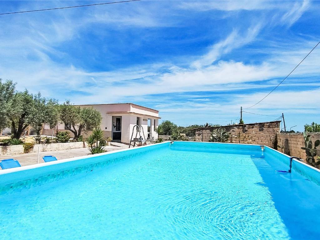 une grande piscine bleue en face d'une maison dans l'établissement Holiday Home Brunella by Interhome, à Carlentini