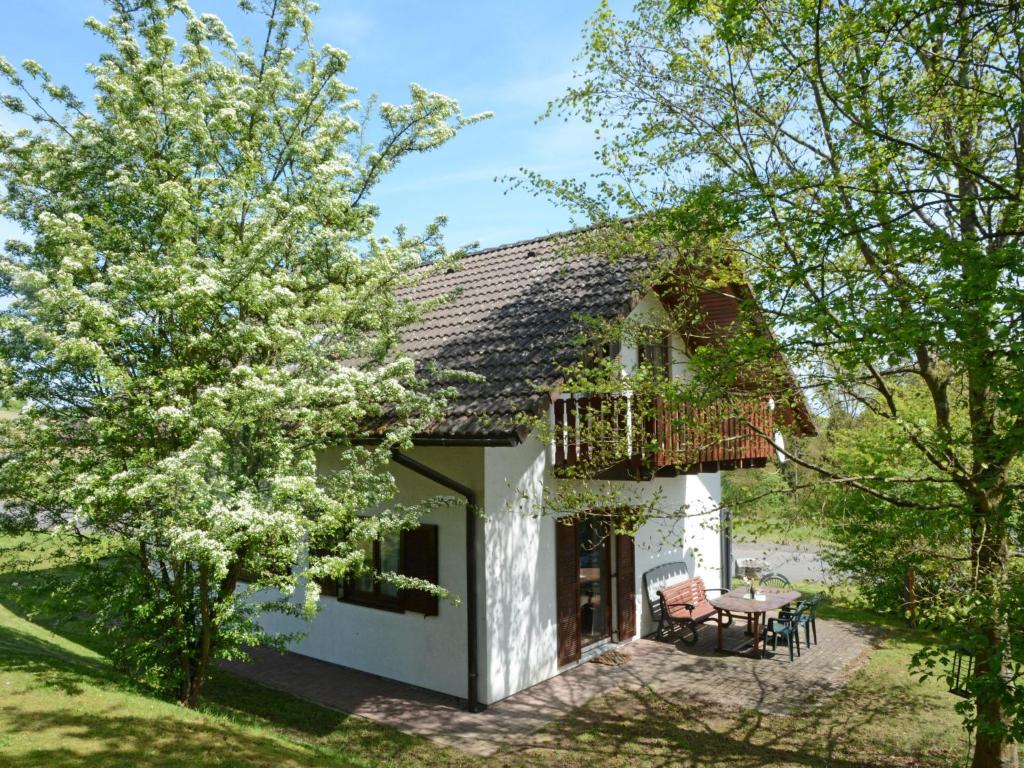 ein Haus mit einem Balkon und einem Tisch in der Unterkunft Holiday Home Dorf 4- Haus 27 by Interhome in Kirchheim