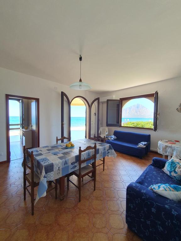 a living room with a table and a blue couch at Villino Maria Elena in Valderice