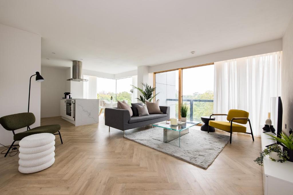 un soggiorno con divano e sedie di Modern, Luxury 2-Bed Home with Private Balcony a Londra