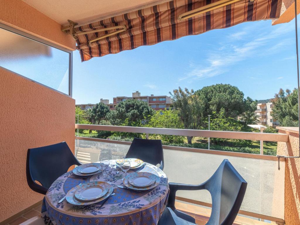 une table et des chaises sur un balcon avec vue dans l'établissement Apartment L'Amirauté by Interhome, à Bormes-les-Mimosas