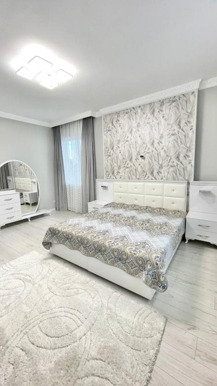 une chambre blanche avec un lit et un mur dans l'établissement # 51 Светлая квартира в ЖК Лагуна, à Atyraū