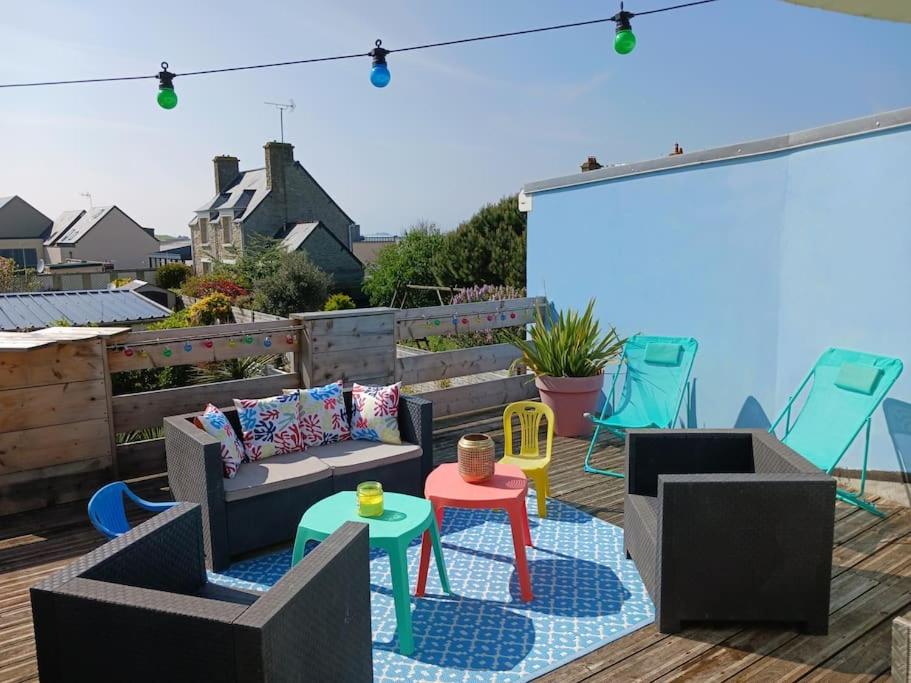 un patio avec un canapé et des tables sur une terrasse dans l'établissement Sea food and Beach Le grand Cherbourg, à Cherbourg en Cotentin