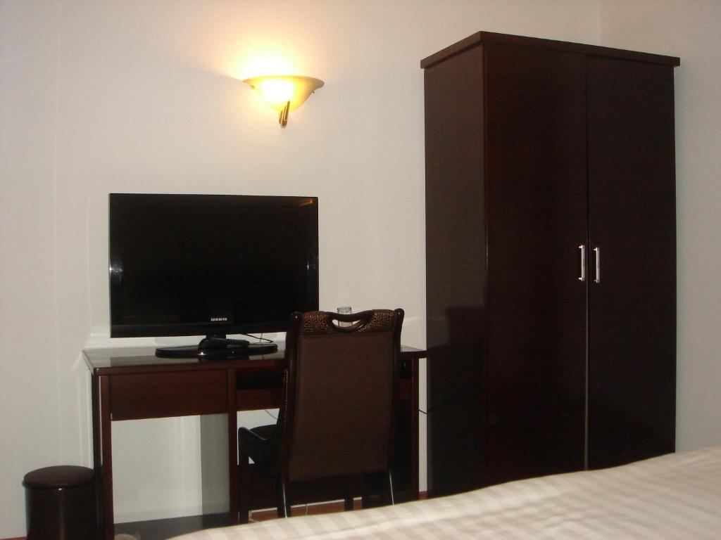 1 dormitorio con escritorio, ordenador y armario en Hotel Restaurant Dao, en Foetz