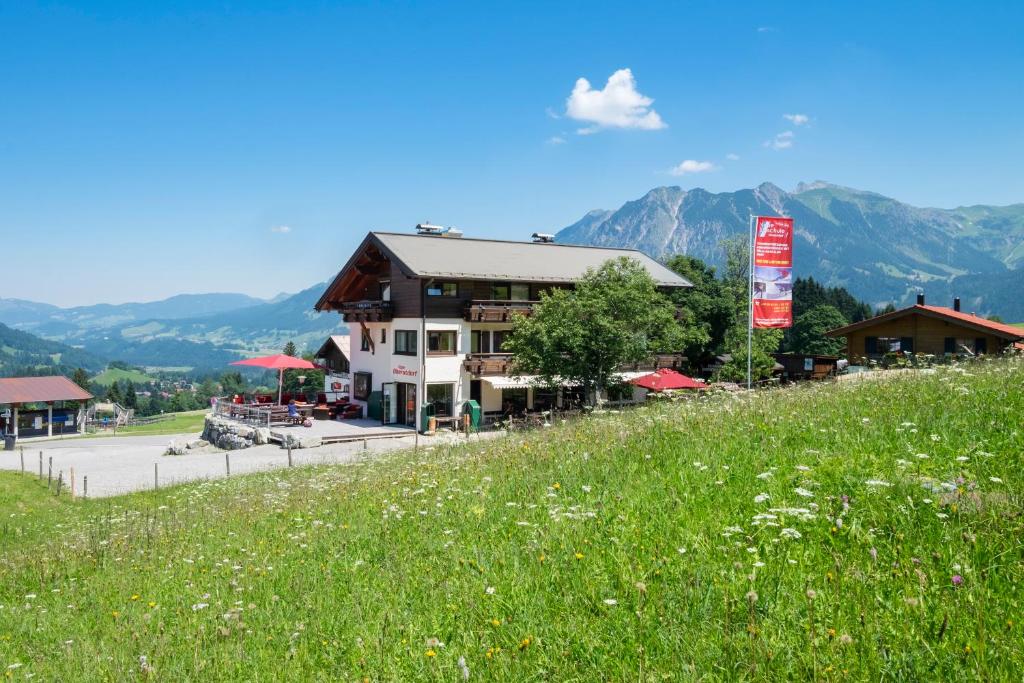 a building on a hill with a field of grass at Alpe Oberstdorf in Oberstdorf