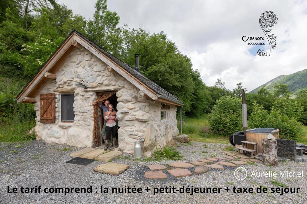 dos personas de pie en la puerta de una cabaña pequeña en Cabanots - Ecolodges en Vallée d'Ossau à 900m d'altitude, 