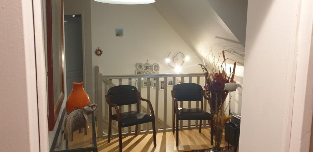 un escalier avec trois chaises et un vase dans l'établissement Claude et Martine, à Villeparisis