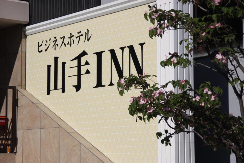 um sinal na lateral de um edifício em ビジネスホテル 山手INN em Iidamachi