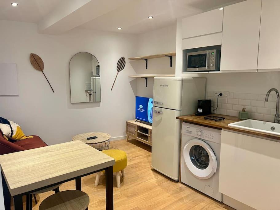 une petite cuisine avec un lave-linge et une table dans l'établissement Chez Bénédicte, à Montpellier