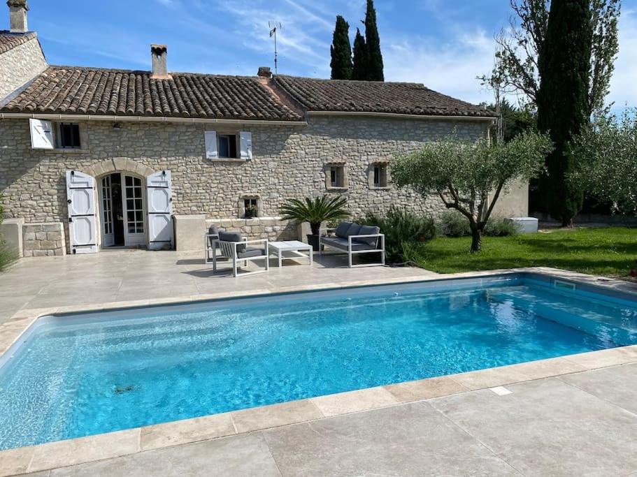 - une piscine en face d'une maison en pierre dans l'établissement Mas avec piscine entre Alpilles et Luberon, à Sénas