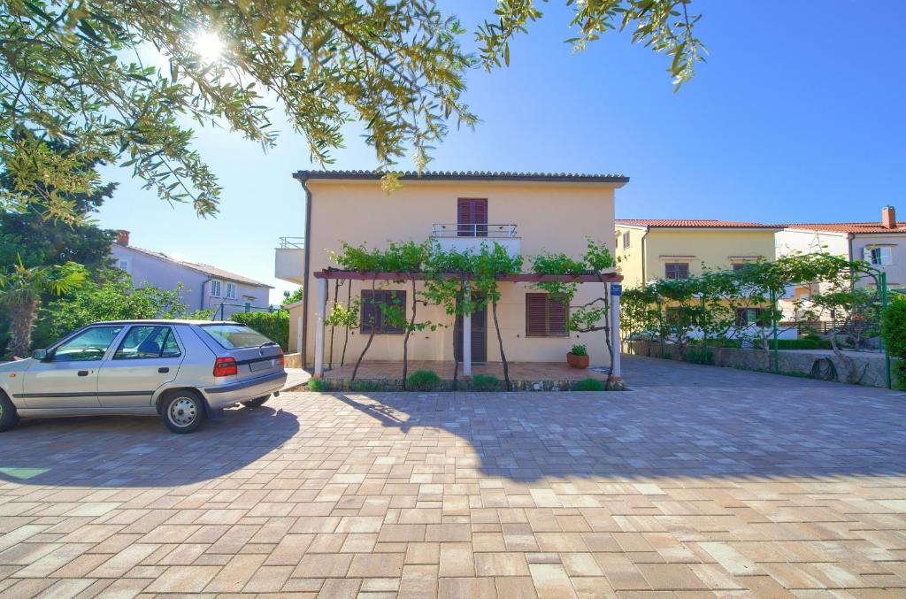 samochód zaparkowany przed domem w obiekcie Apartman Sokolovski w Krku