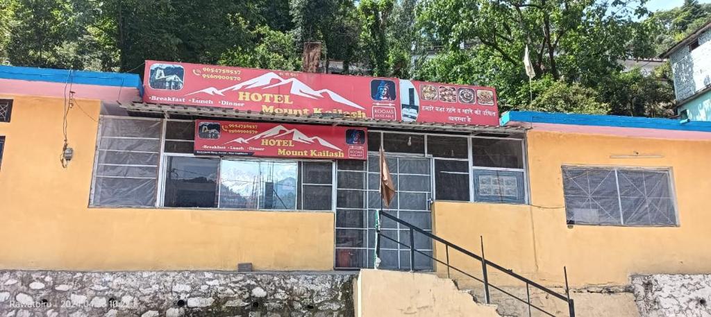 ein Gebäude mit Schildern oben drauf in der Unterkunft Hotel Mount Kailash in Gupta Kāshi
