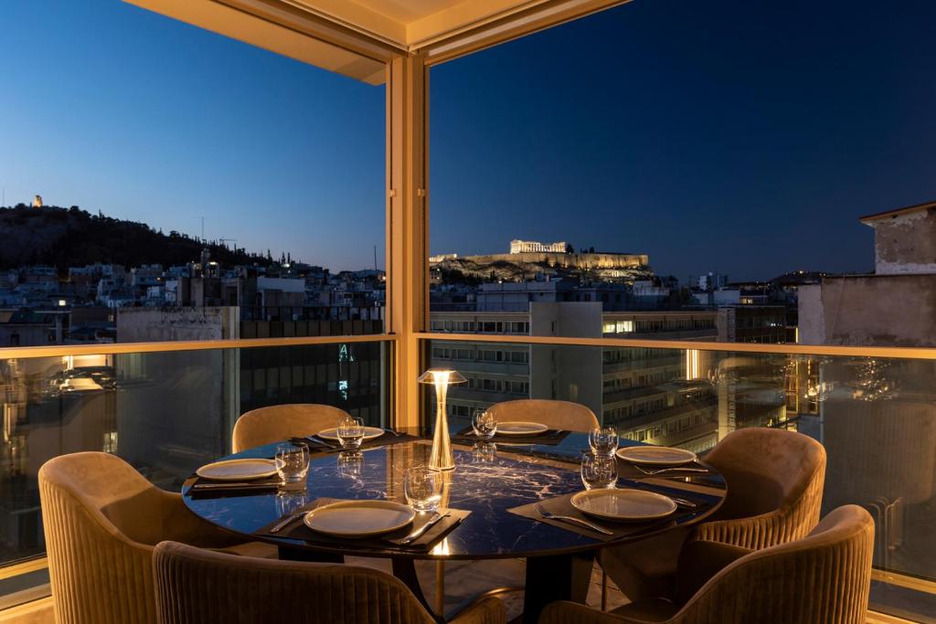 a table on a balcony with a view of a city at Heritage Hill Hotel in Athens