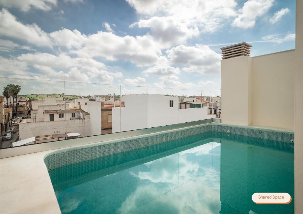 a swimming pool on the roof of a building at Los Olivos Apartments by Olala Homes in Seville