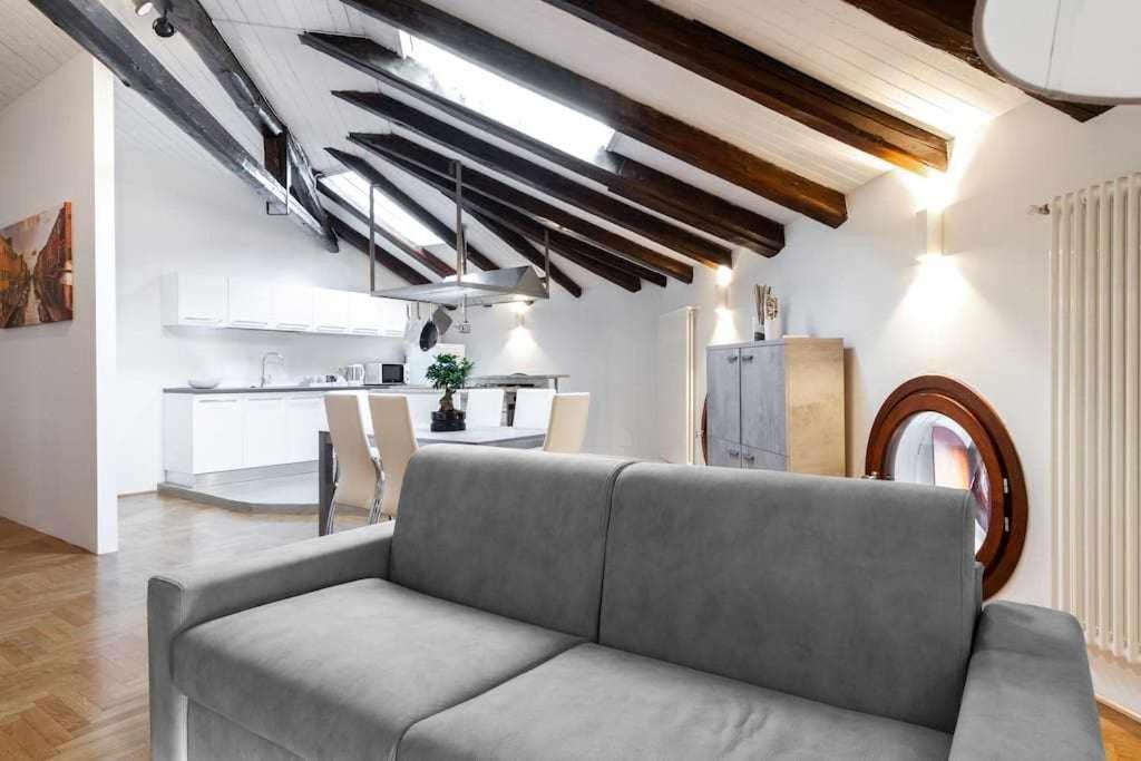 a living room with a couch and a kitchen at Attic floor venice apartment in Mestre
