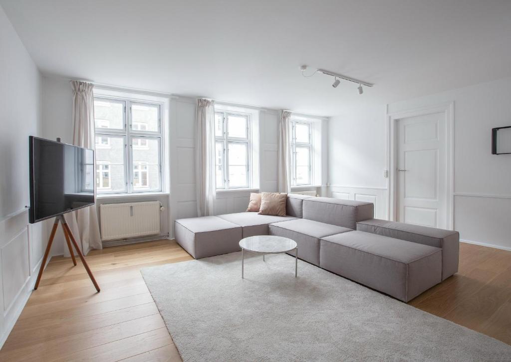 uma sala de estar com um sofá e uma televisão em Beautiful 2-bed in top Copenhagen location em Copenhague
