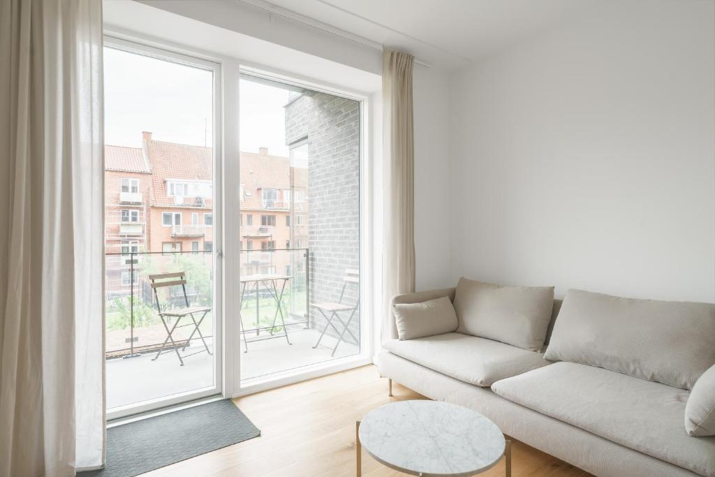 a living room with a couch and a large window at Fantastic 2-bed apartment with balcony in Odense